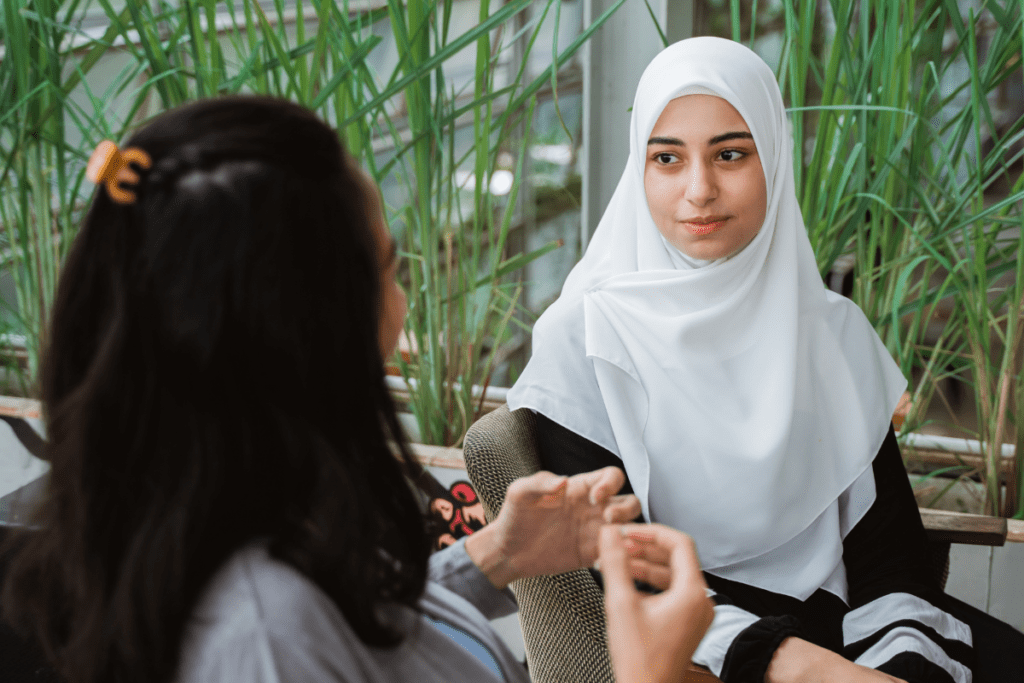 woman in a hijab being interviewed by another woman in relation to Project Willow's research on racialized Muslim women's experiences of homelessness and gender-based violence