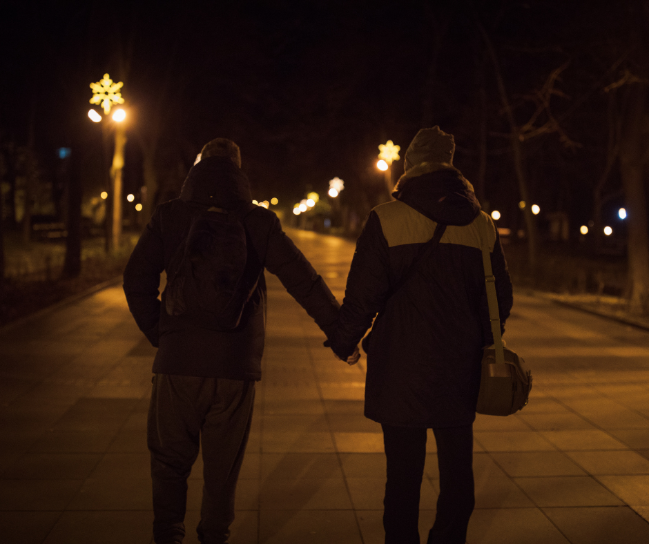 Couple walking down a dark street.